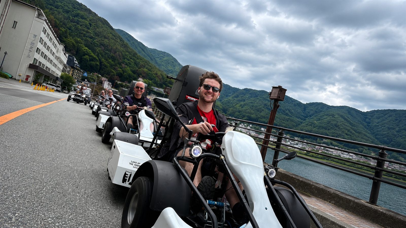 Guided electric go-kart convoy along the lakeside road